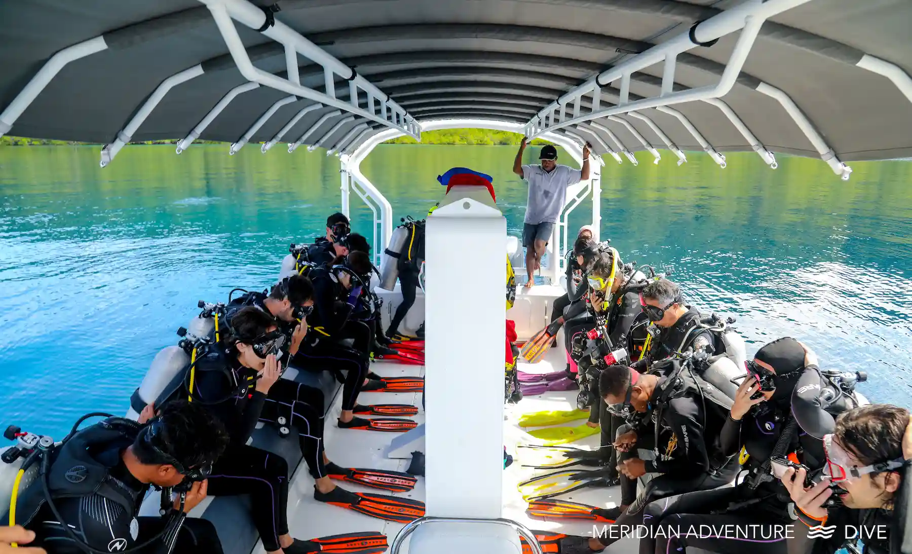 Scuba divers preparing aboard a Meridian Adventure dive boat in Raja Ampat